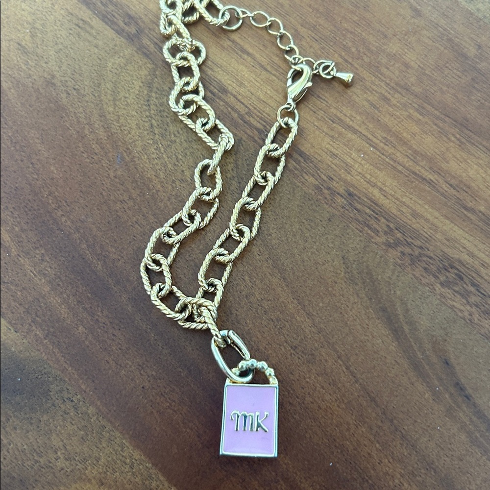 Michael Kors Gold tone bracelet with Pink Pendant